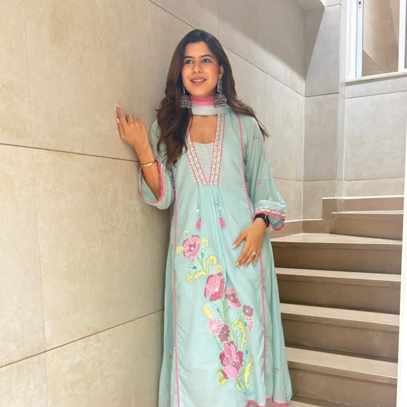 Model in a rust lehenga against a Vadodara haveli archway
